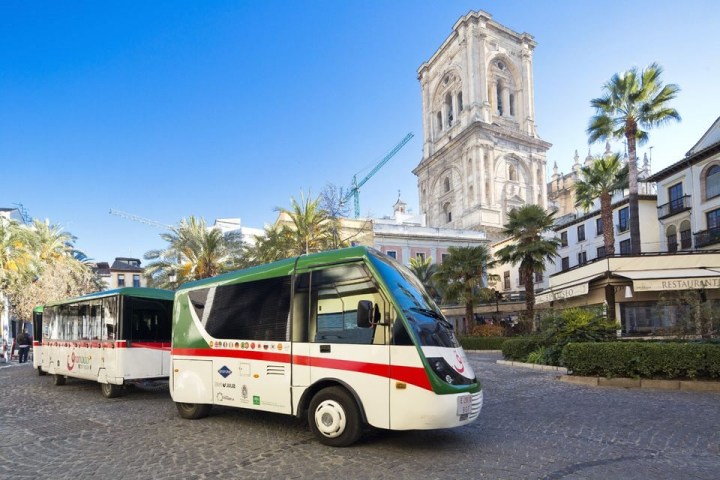 a passenger bus that is parked on the side of a building