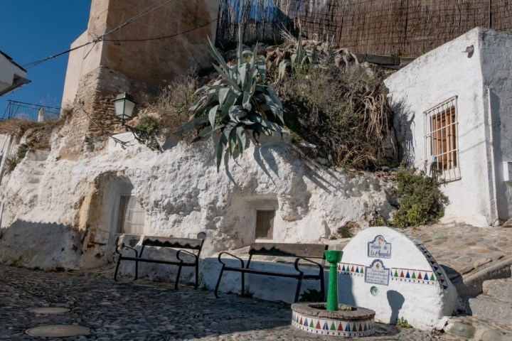 a person sitting on a bench in front of a building